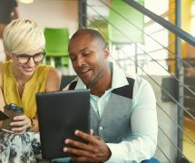 A team of millennial business owners collaborating on an online project using a touchpad tablet in a modern office space. (Photo: AdobeStock/AYAimages)