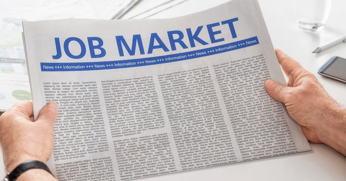 Man reading newspaper with the headline Job Market. (Photo: AdobeStock)