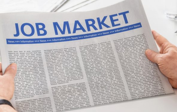 Man reading newspaper with the headline Job Market. (Photo: AdobeStock)