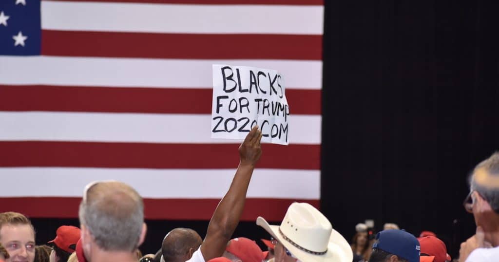 An African American supporter of President Donald Trump holds up a Black for Trump sign during a rally in Tampa, Florida on Tuesday, July 31, 2018. (Photo: Laura Baris/People's Pundit Daily)
