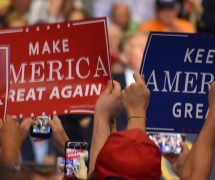 Supporters of President Donald Trump hold up Make America Great American and Keep America Great signs A supporter of Donald Trump dons a T-shirt with a new twist on an old joke targeting Hillary Clinton during a rally in Tampa, Florida on Tuesday, July 31, 2018. (Photo: Laura Baris/People's Pundit Daily)