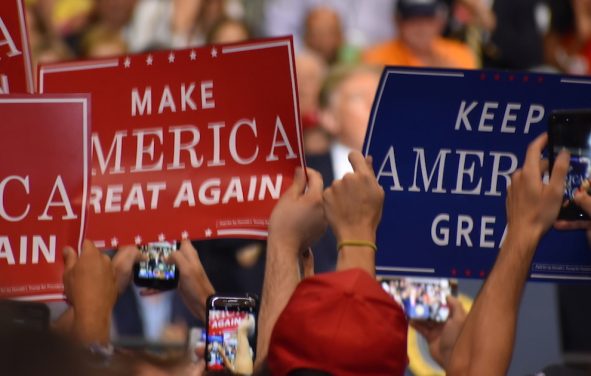 Supporters of President Donald Trump hold up Make America Great American and Keep America Great signs A supporter of Donald Trump dons a T-shirt with a new twist on an old joke targeting Hillary Clinton during a rally in Tampa, Florida on Tuesday, July 31, 2018. (Photo: Laura Baris/People's Pundit Daily)
