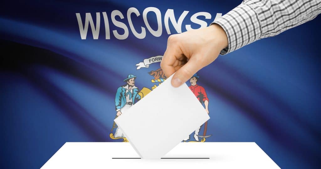 Voting, elections and state polls concept: Ballot box with state flag in the background - Wisconsin. (Photo: AdobeStock)