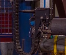 Manufacture of rails for trains and freight wagon, boxcars. Rail manufacturing plant. Stack of steel round bar - iron metal rail lines material for industry construction in warehouse. (Photo: AdobeStock)
