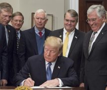 President Donald Trump signs the Presidential Space Directive - 1, directing NASA to return to the moon, alongside members of the Senate, Congress, NASA, and commercial space companies in the Roosevelt room of the White House in Washington, Monday, Dec. 11, 2017. Photo Credit: (NASA/Aubrey Gemignani)