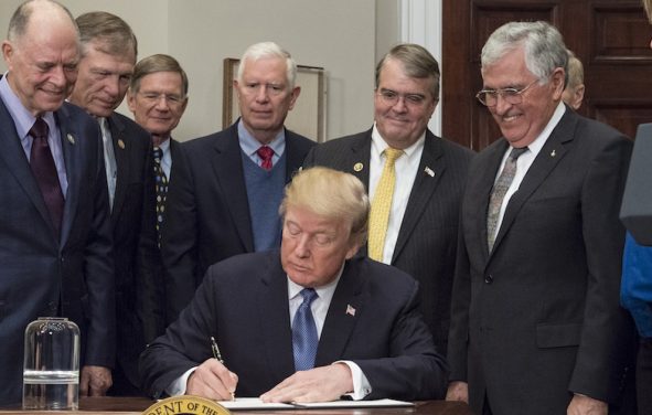 President Donald Trump signs the Presidential Space Directive - 1, directing NASA to return to the moon, alongside members of the Senate, Congress, NASA, and commercial space companies in the Roosevelt room of the White House in Washington, Monday, Dec. 11, 2017. Photo Credit: (NASA/Aubrey Gemignani)