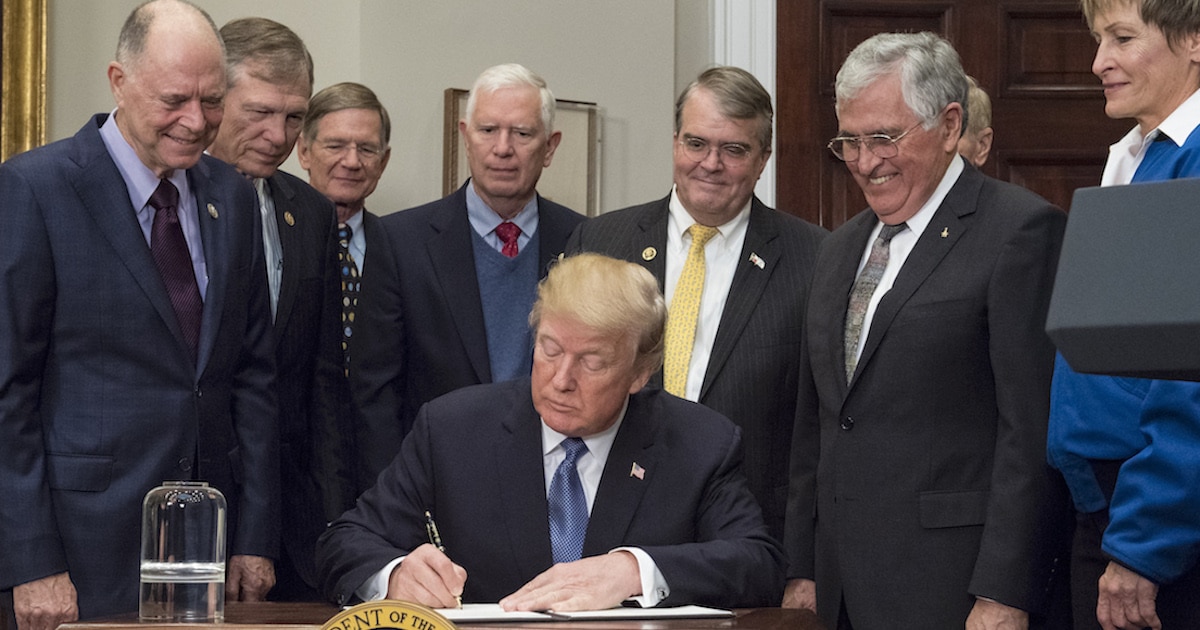President Donald Trump signs the Presidential Space Directive - 1, directing NASA to return to the moon, alongside members of the Senate, Congress, NASA, and commercial space companies in the Roosevelt room of the White House in Washington, Monday, Dec. 11, 2017. Photo Credit: (NASA/Aubrey Gemignani)