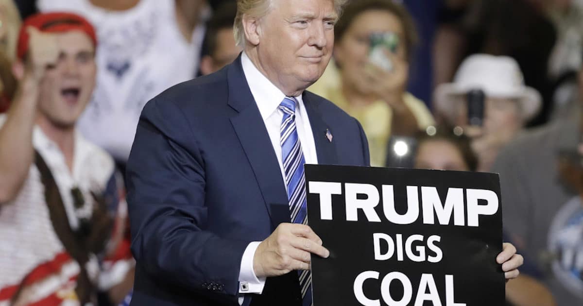 Donald Trump holds up a "Trump Digs Coal" placard at a rally promising to bring back the coal industry in West Virginia, Ohio and elsewhere.