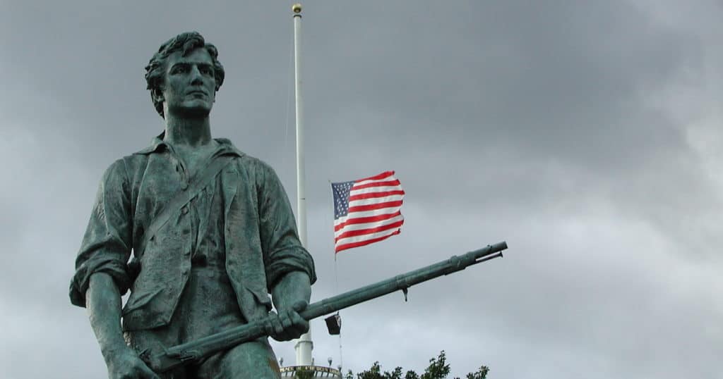 Summer's End. Lexington Green, 11 September 2002. Photo taken in Minute Man National Historical Park, with flag at half staff on the first anniversary of the terrorist attacks of 11 September 2001. Sculpture : "Minuteman" by sculptor Henry Hudson Kitson (1863-1947), dedicated April 19, 1900. Erected 1899. (Wiki via Aldaron CC)