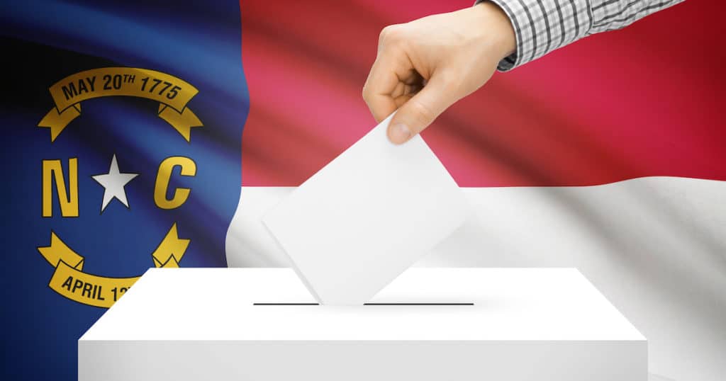 Voting, elections and state polls concept: Ballot box with state flag in the background - North Carolina. (Photo: AdobeStock)