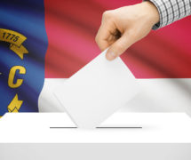 Voting, elections and state polls concept: Ballot box with state flag in the background - North Carolina. (Photo: AdobeStock)