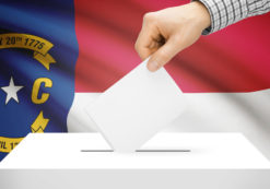 Voting, elections and state polls concept: Ballot box with state flag in the background - North Carolina. (Photo: AdobeStock)