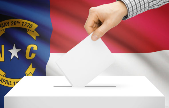 Voting, elections and state polls concept: Ballot box with state flag in the background - North Carolina. (Photo: AdobeStock)