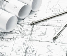 Construction planning drawings on the table and a compass. (Photo: AdobeStock)