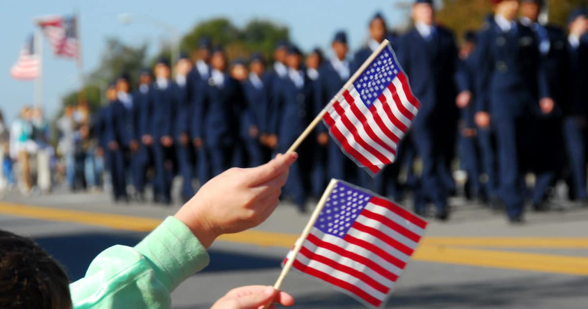 Flag waving at a Veterans Day parade. (Photo: AdobeStock)