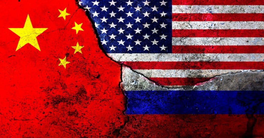 Cracks in the wall painted with the flags for the United States of America (USA), the People's Republic of China and the Russian Federation. (Photo: AdobeStock)