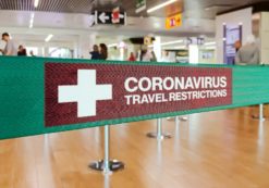 Green ribbon barrier inside an airport with the warning of travel restrictions due to the spread of the Coronavirus, or COVID-19. (Photo: AdobeStock)