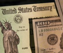 United States Treasury check surrounded by U.S. currency to illustrate a stimulus package or income tax refunds from the Internal Revenue Service (IRS). (Photo: AdobeStock)