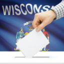 Voting, elections and state polls concept: Ballot box with state flag in the background - Wisconsin. (Photo: AdobeStock)