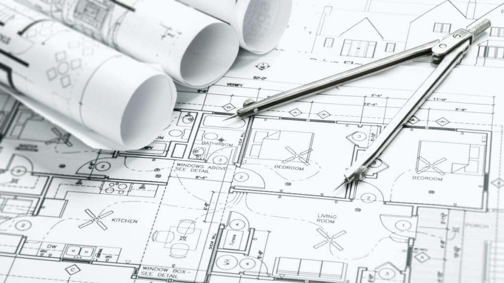 Construction planning drawings on the table and two yellow pencils to illustrate total construction spending data and projects. (Photo: AdobeStock)