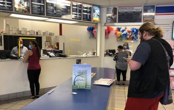 United States Postal Service (USPS) workers don face masks and gloves behind plexiglass at the USPS location on N. Main in Gainesville, Fla., during the coronavirus (COVID-19) pandemic. (Photo: People's Pundit Daily/PPD)