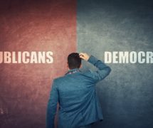 A puzzled businessman and a split wall with Republicans and Democrats written on red and blue sides to illustrate the choice between parties in elections. (Photo: AdobeStock)