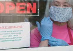 With cautious optimism a small business owner wearing a face mask and disposable gloves posts safety rules as she reopens her store after the coronavirus (COVID-19)shutdown. (Photo: AdobeStock/JHDT Productions)