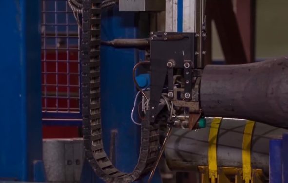 Manufacture of rails for trains and freight wagon, boxcars. Rail manufacturing plant. Stack of steel round bar - iron metal rail lines material for industry construction in warehouse. (Photo: AdobeStock)