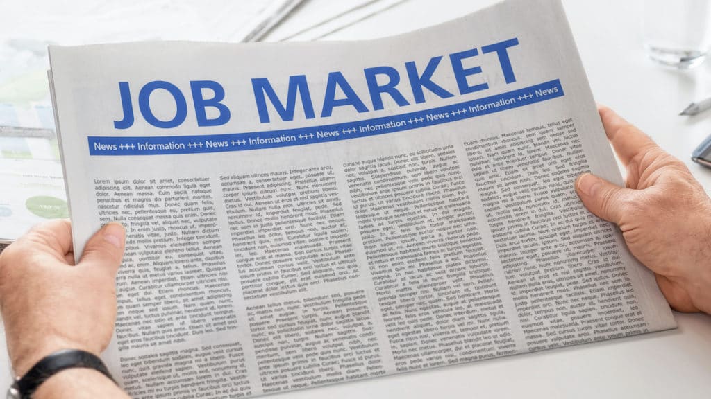 Man reading newspaper with the headline Job Market. (Photo: AdobeStock)