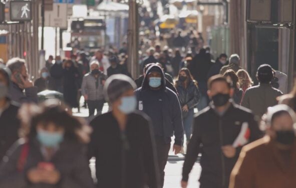 Crowd of people walking the city streets while wearing masks during the coronavirus (Covid-19) pandemic. (Photo: AdobeStock)